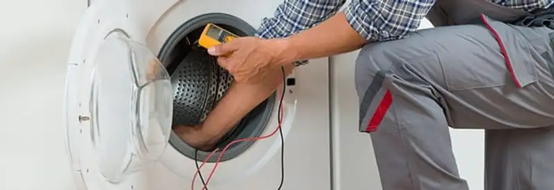 Dryer repair technician inspecting and repairing a clothes dryer in Grand Rapids, MI