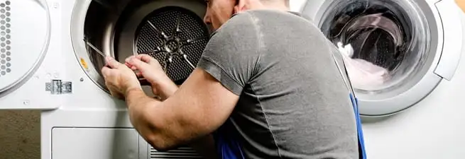 Dryer repair technician fixing a clothes dryer drum in Grand Rapids, MI