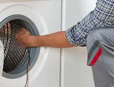 Dryer repair technician diagnosing and servicing a clothes dryer in Grand Rapids, MI