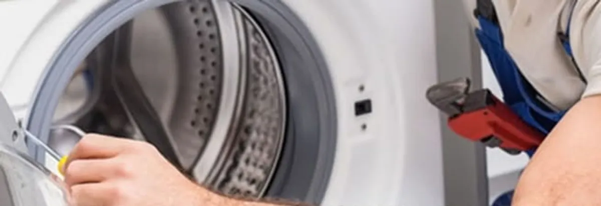 Appliance technician repairing a clothes dryer drum and internal parts in Grand Rapids, MI