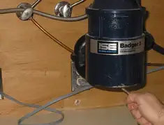 Garbage disposal repair technician tightening the mounting ring under a sink in Grand Rapids, MI