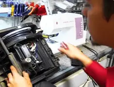 Vacuum repair technician servicing internal components on a workbench in Grand Rapids, MI