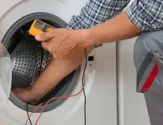 Washing machine repair technician testing a front-load washer with diagnostic tools in Grand Rapids, MI